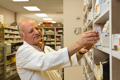 Pharmacist stocks shelves at an affordable community pharmacy