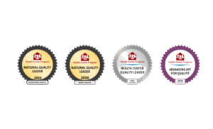 A row of four Health Connect America Program recognition badges. The first and second badges are gold-toned National Quality Leader awards for 2026 with a red house logo at the center. The third badge is a silver Quality Leader award with the same logo and metallic styling. The fourth badge is a dark-themed National Quality Leader badge with a purple border. Each badge is circular with a scalloped edge and includes a small recognition plate beneath the main emblem.