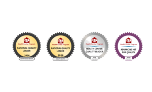 A row of four Health Connect America Program recognition badges. The first and second badges are gold-toned National Quality Leader awards for 2026 with a red house logo at the center. The third badge is a silver Quality Leader award with the same logo and metallic styling. The fourth badge is a dark-themed National Quality Leader badge with a purple border. Each badge is circular with a scalloped edge and includes a small recognition plate beneath the main emblem.