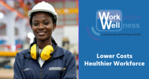 Workplace wellness promotional graphic featuring a worker in industrial safety gear standing in a manufacturing setting. The individual is wearing a white hard hat, a dark work uniform, and yellow hearing protection resting around the neck. On the right side of the graphic, the Workplace Wellness logo appears with the text “in partnership with Kintegra Health.” Large white text reads: “Lower Costs. Healthier Workforce.” The design uses a blue background and emphasizes employee health, workplace wellness, and occupational well-being.
